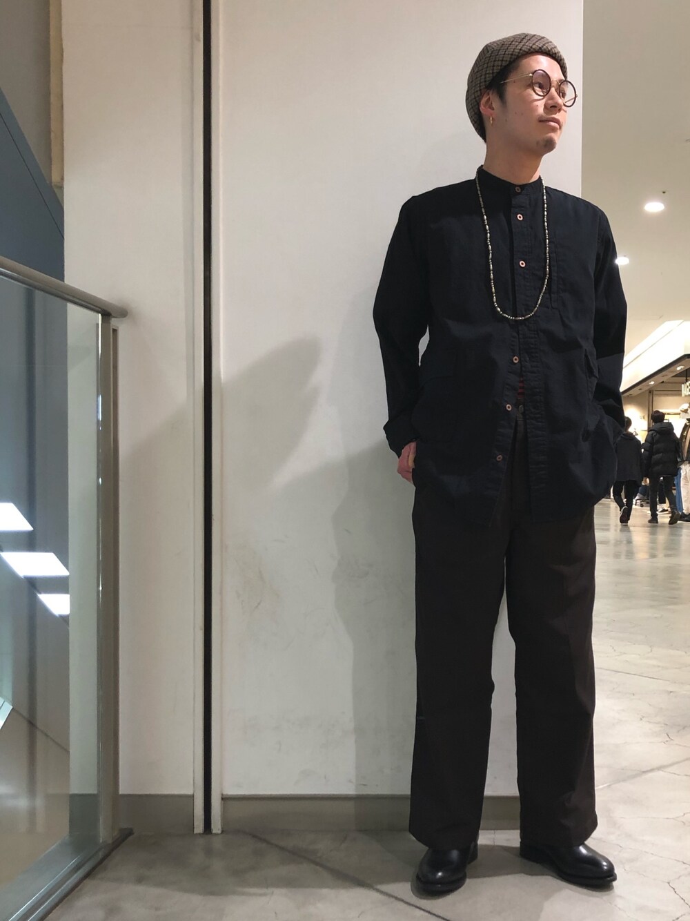 ブラック系のシャツ/ブラウス、ブラウン系のスラックス、ブラック系のブーツを着用したメンズの冬コーディネートの1枚目の写真