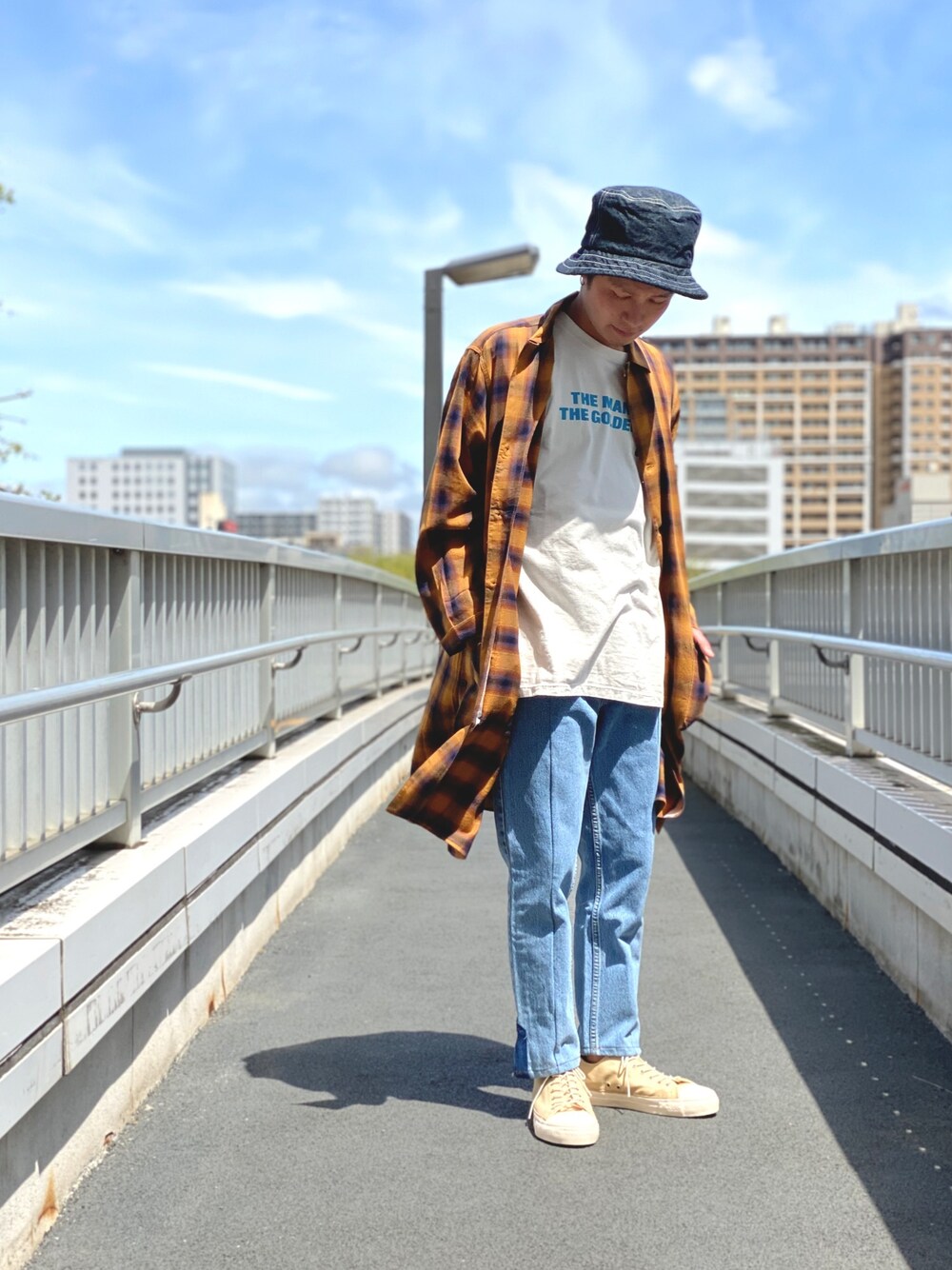 ブラウン系のシャツ/ブラウス、ホワイト系のTシャツ/カットソー、ブルー系のパンツを着用したメンズの春コーディネートの1枚目の写真