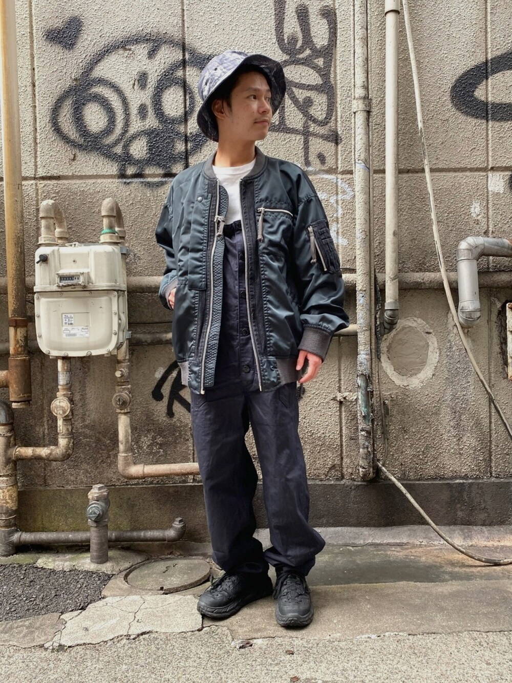 ブラック系のMA-1、ブラック系のオールインワン・サロペット、ホワイト系のTシャツ/カットソーを着用したメンズの夏コーディネートの1枚目の写真