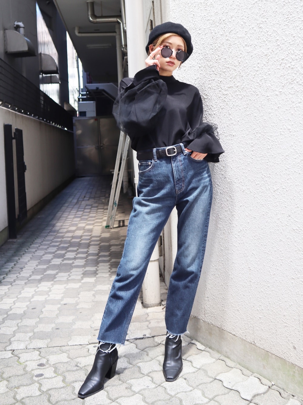 ブラック系のTシャツ/カットソー、ブルー系のデニムパンツを着用したレディースの秋コーディネートの1枚目の写真