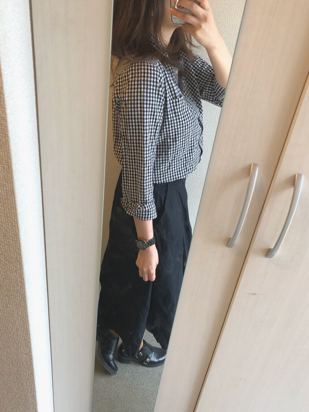 ブラック系のシャツ/ブラウス、ブルー系のスカート、ブラック系のブーティを着用したレディースの秋コーディネートの1枚目の写真