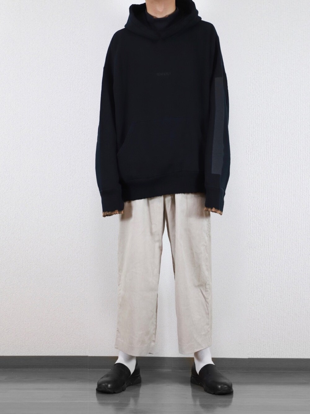 ブラック系のパーカー、ブラック系のTシャツ/カットソー、ホワイト系のその他パンツを着用したメンズの秋コーディネートの1枚目の写真