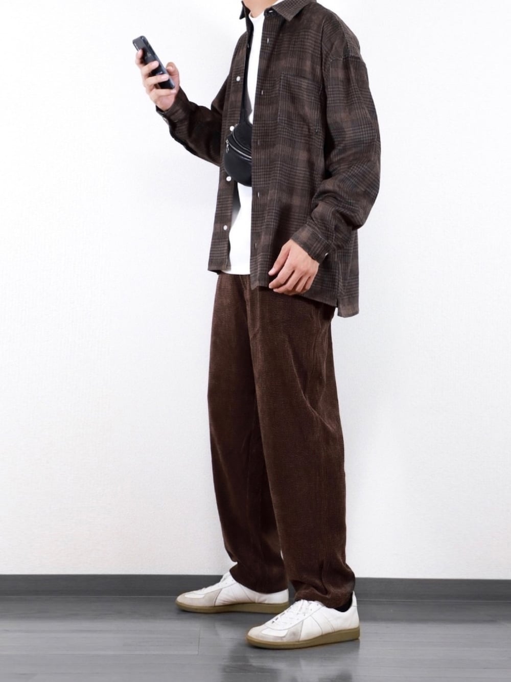 ホワイト系のスウェット、ブラウン系のその他パンツ、ブラック系のボディバッグ/ウエストポーチを着用したメンズの秋コーディネートの1枚目の写真