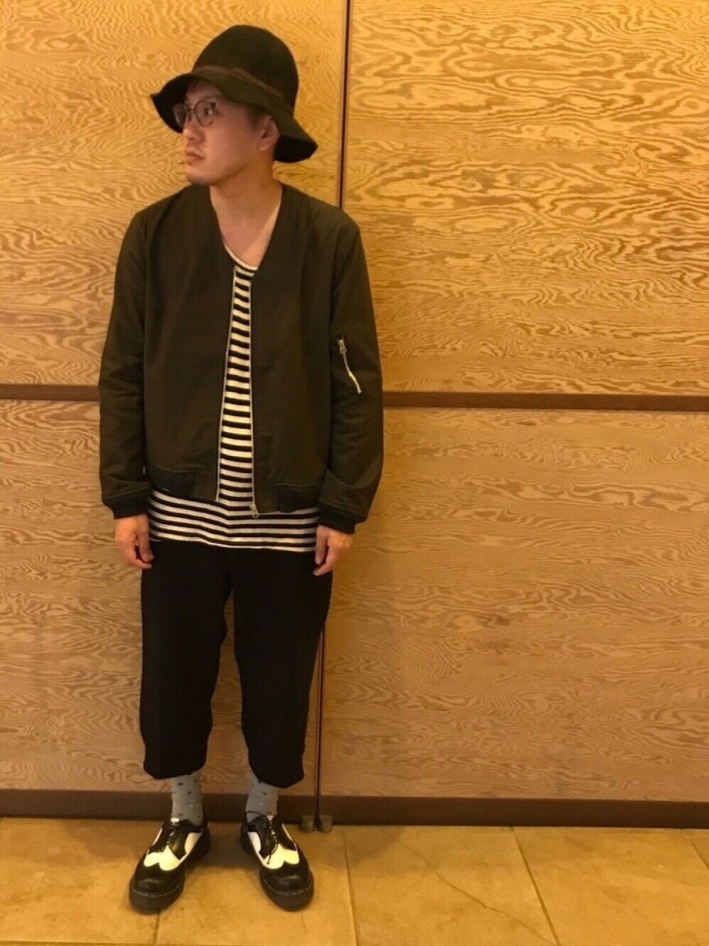 ブラック系のミリタリージャケット、ブラック系のその他パンツ、ホワイト系のブーツを着用したメンズの春コーディネートの1枚目の写真