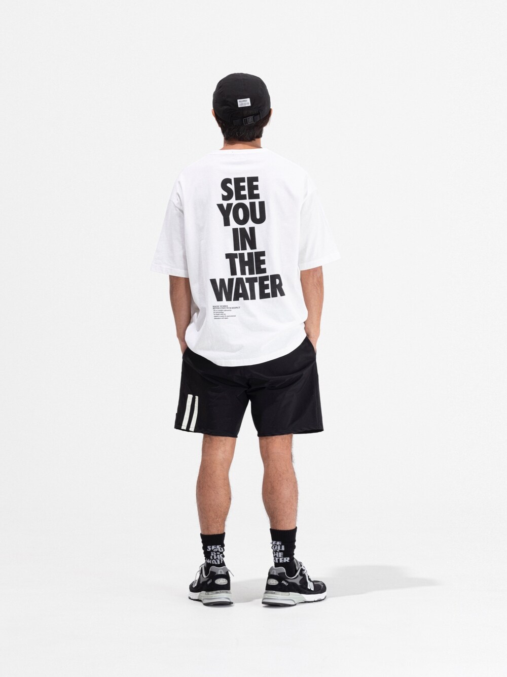 ホワイト系のTシャツ/カットソー、ブラック系の水着、ブラック系のキャップを着用したメンズの春コーディネートの1枚目の写真