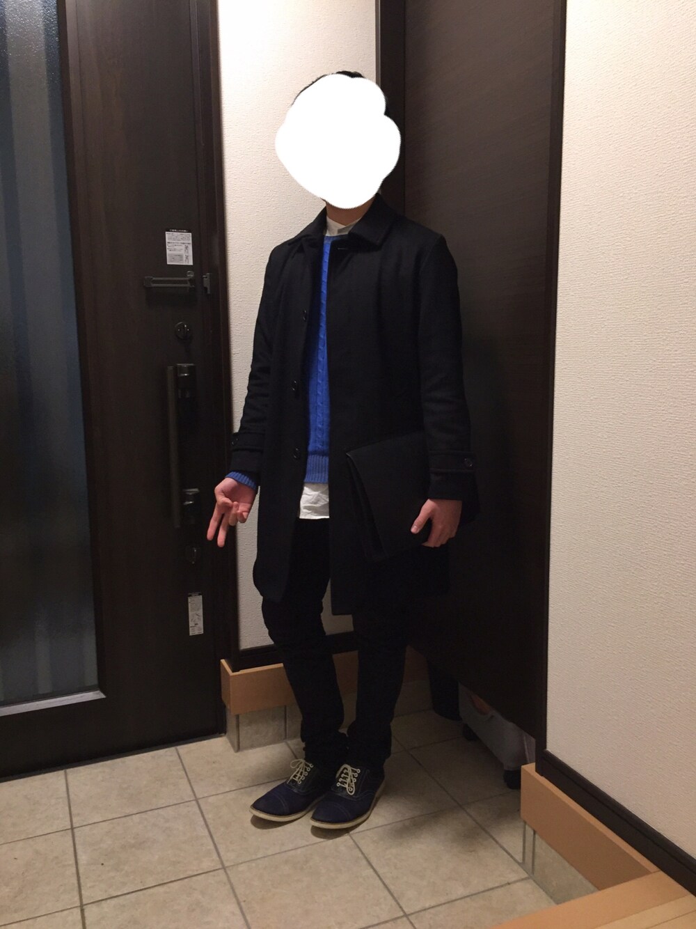 ブラック系のステンカラーコート、ブルー系のニット/セーター、ホワイト系のシャツ/ブラウスを着用したメンズの冬コーディネートの1枚目の写真