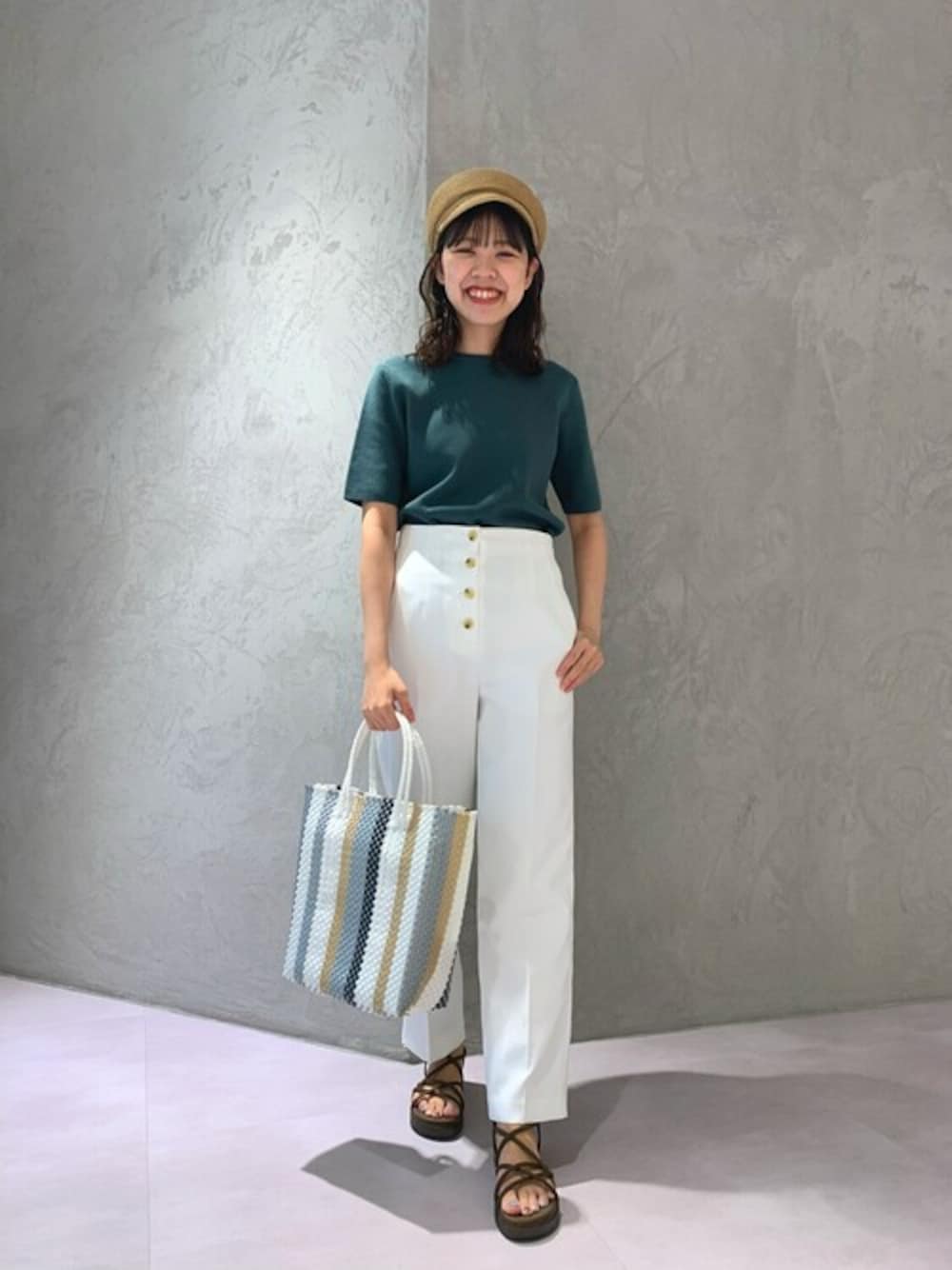 グリーン系のニット/セーター、ホワイト系のその他パンツ、ホワイト系のトートバッグを着用したレディースの夏コーディネートの1枚目の写真
