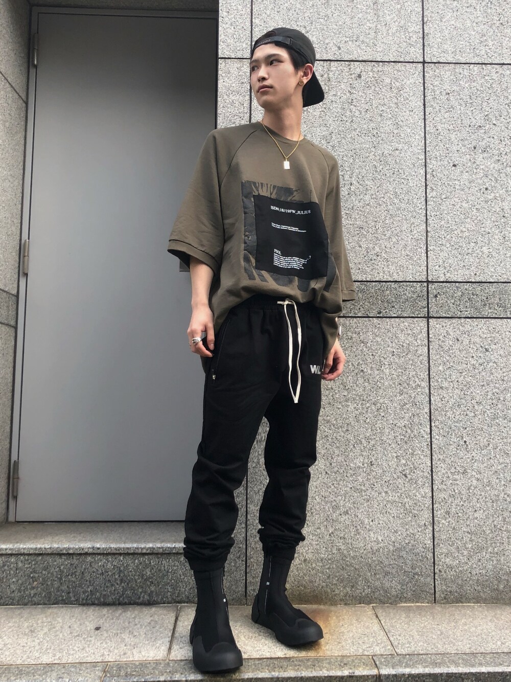 グリーン系のTシャツ/カットソー、ブラック系のその他パンツ、ブラック系のスニーカーを着用したメンズの夏コーディネートの1枚目の写真