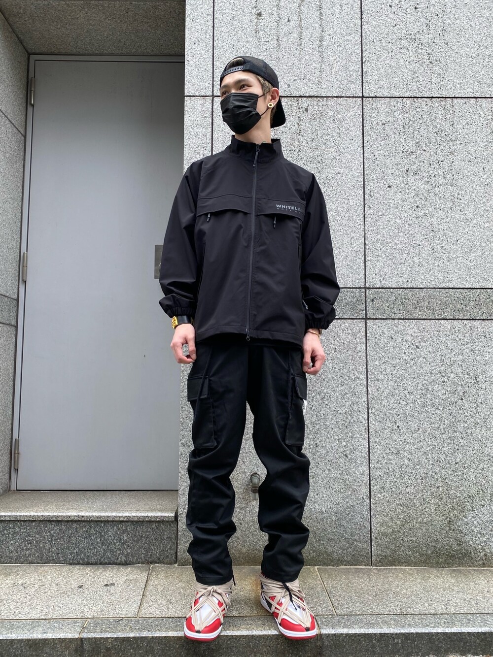 「スニーカー、ブラック、キャップ、ブラックコーデ、ストリート、スニーカーコーデ、カーゴパンツ、ナイロンジャケット、ジャケットスタイル、ストリートコーデ」｜「WHITELANDのWHITELAND/ホワイトランド/ワークトラックジャケット（ブルゾン、ブラック系）」を使った、𝐊𝐚𝐢𝐭𝐨さん（メンズ・180cm）の春コーディネートの1枚目の写真