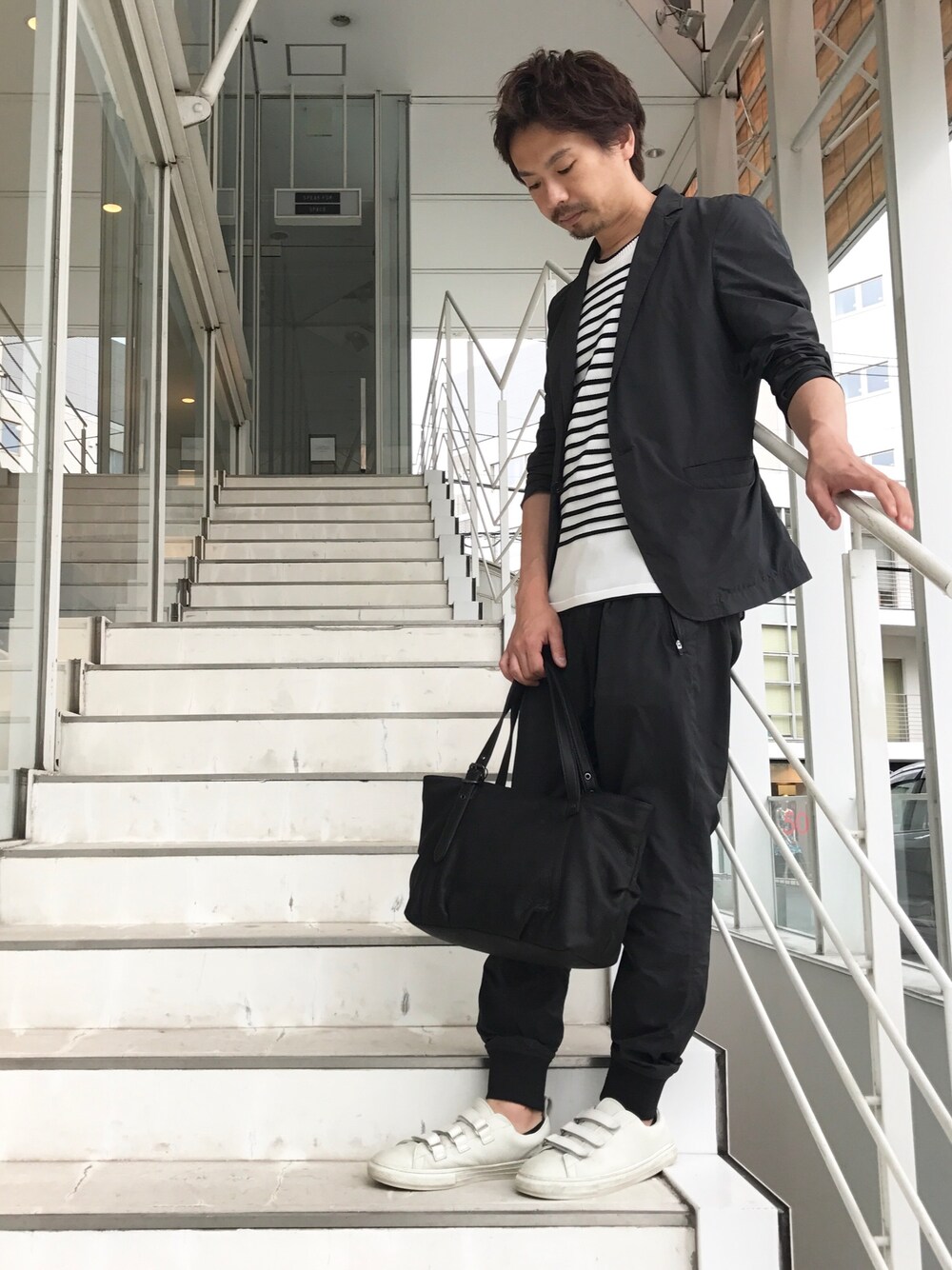 ブラック系のテーラードジャケット、ブラック系のその他パンツ、ホワイト系のTシャツ/カットソーを着用したメンズの夏コーディネートの1枚目の写真