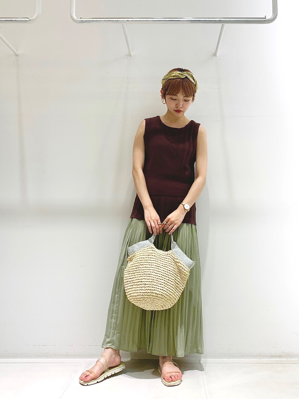 ブラウン系のニット/セーター、シルバー系のトートバッグ、グリーン系のスカートを着用したレディースの夏コーディネートの1枚目の写真