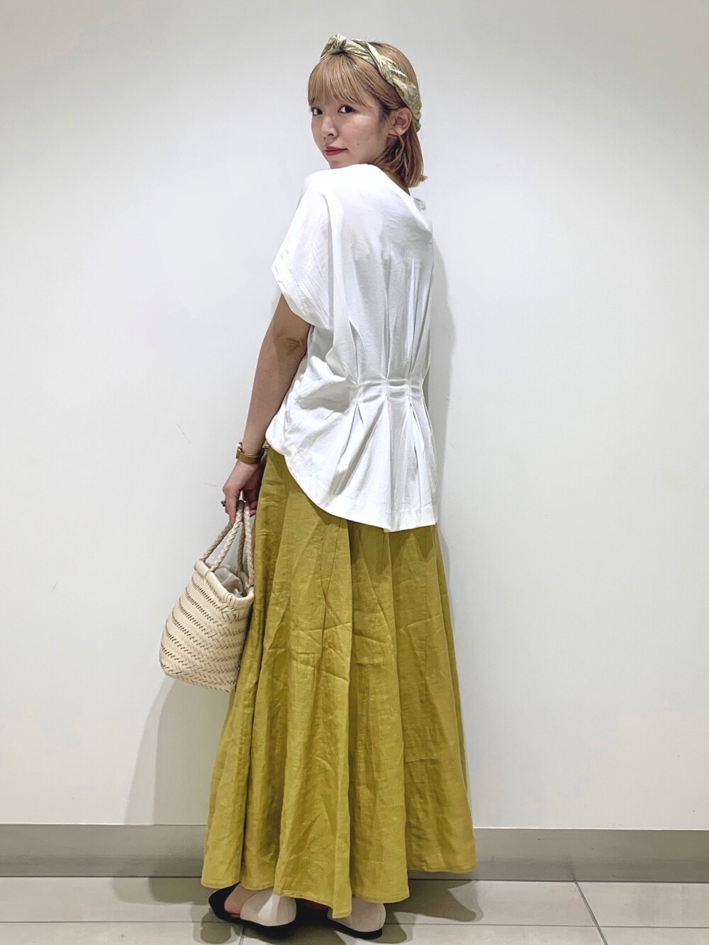 ホワイト系のTシャツ/カットソー、イエロー系のスカート、ホワイト系のトートバッグを着用したレディースの夏コーディネートの1枚目の写真