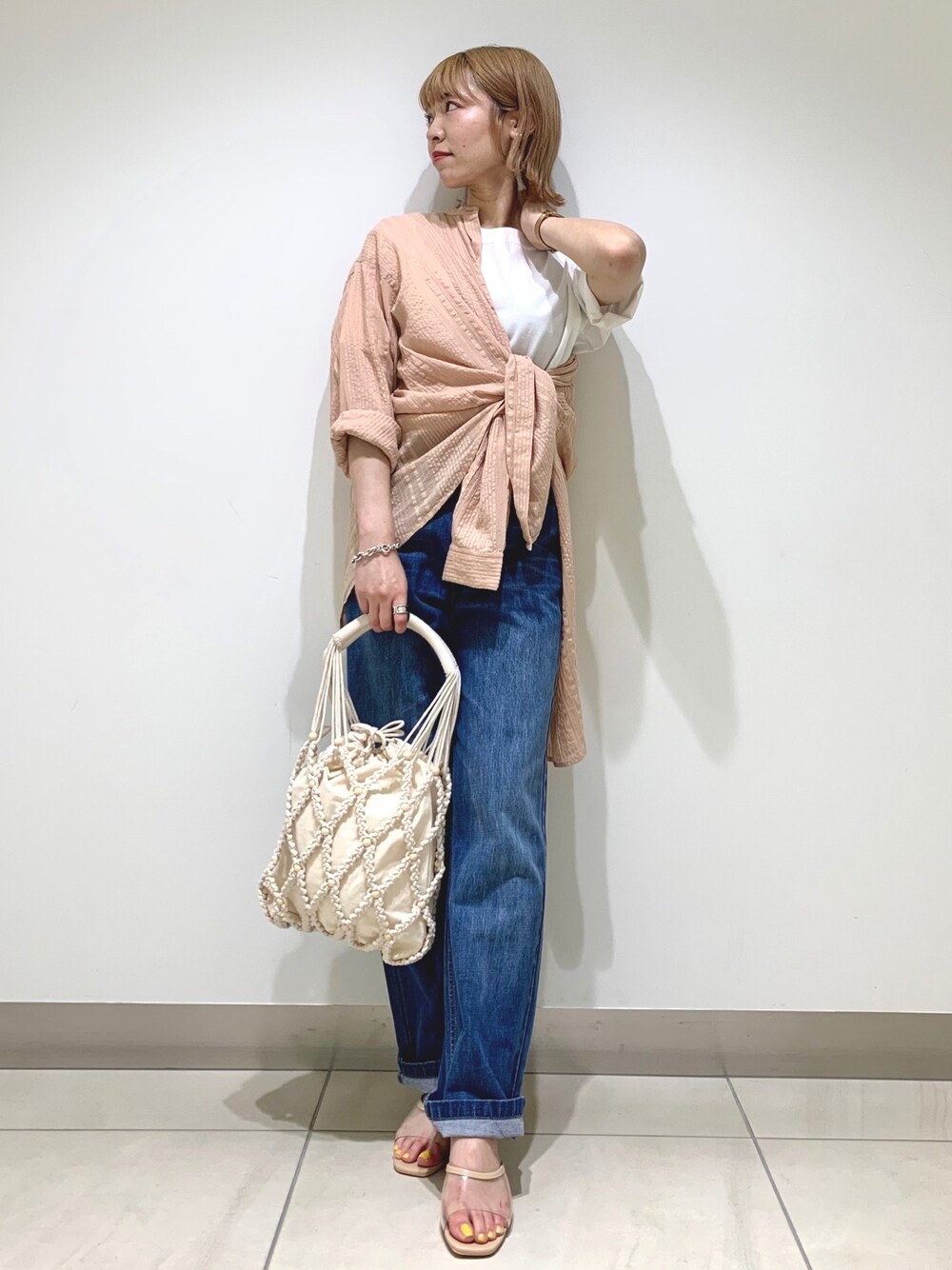 ベージュ系のシャツ/ブラウス、ブルー系のデニムパンツ、ベージュ系のトートバッグを着用したレディースの夏コーディネートの1枚目の写真