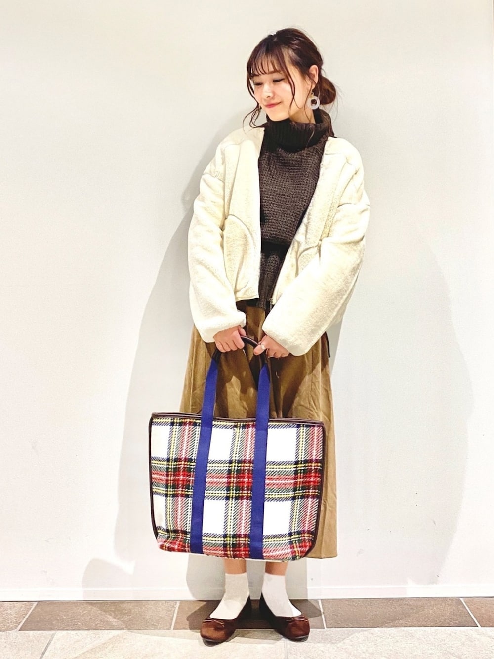 ホワイト系のブルゾン、ブラウン系のニット/セーター、ベージュ系のスカートを着用したレディースの秋コーディネートの1枚目の写真