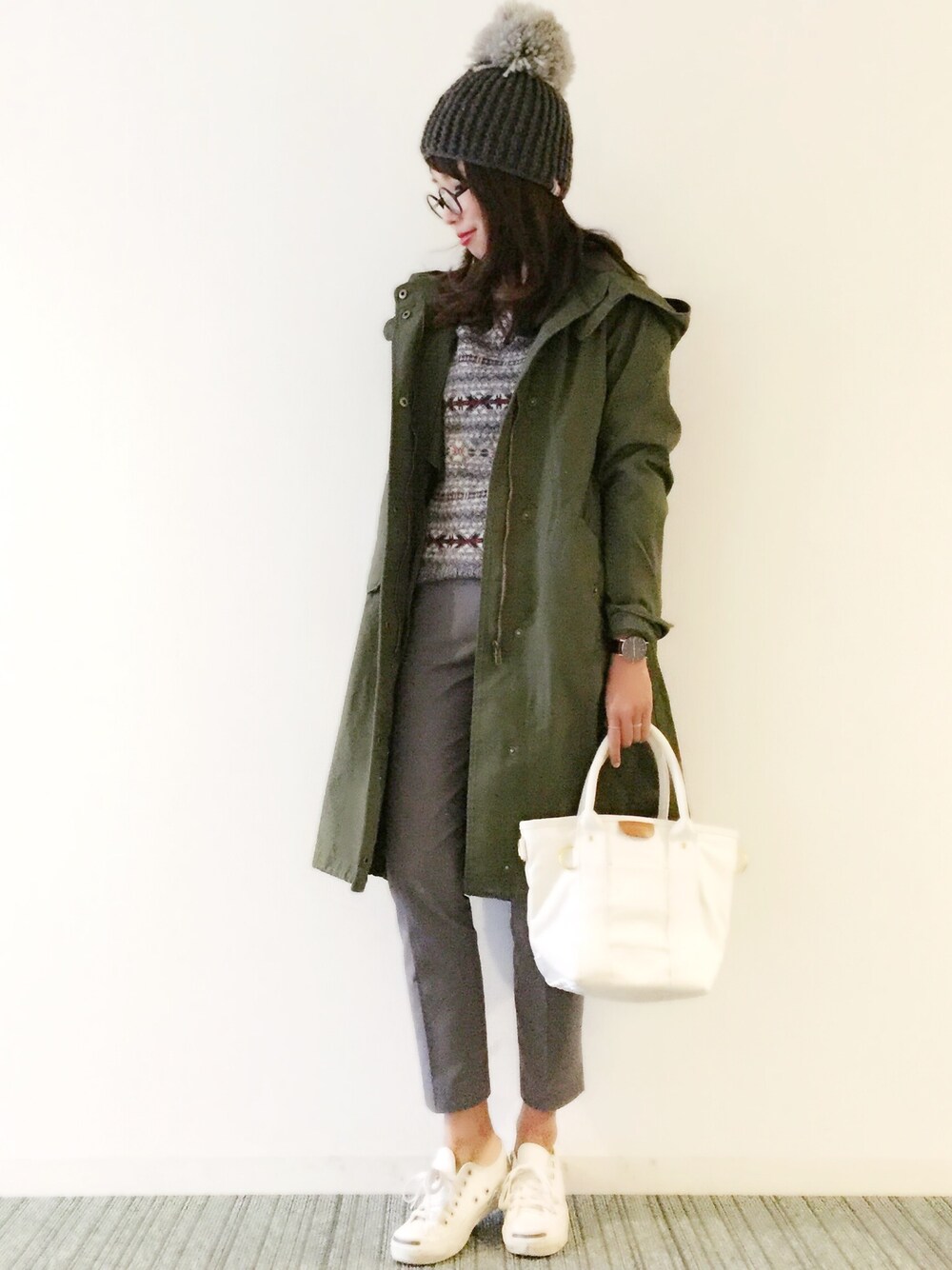 グリーン系のモッズコート、ホワイト系のトートバッグ、ホワイト系のスニーカーを着用したレディースの冬コーディネートの1枚目の写真