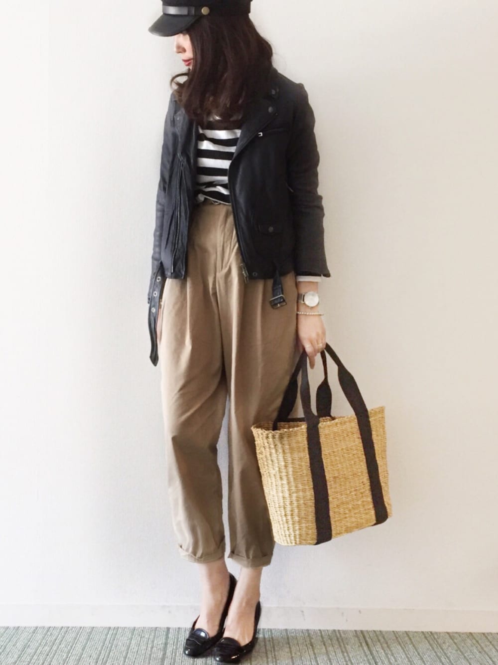 ベージュ系のかごバッグ、ブラック系のパンプス、ベージュ系のパンツを着用したレディースの冬コーディネートの1枚目の写真