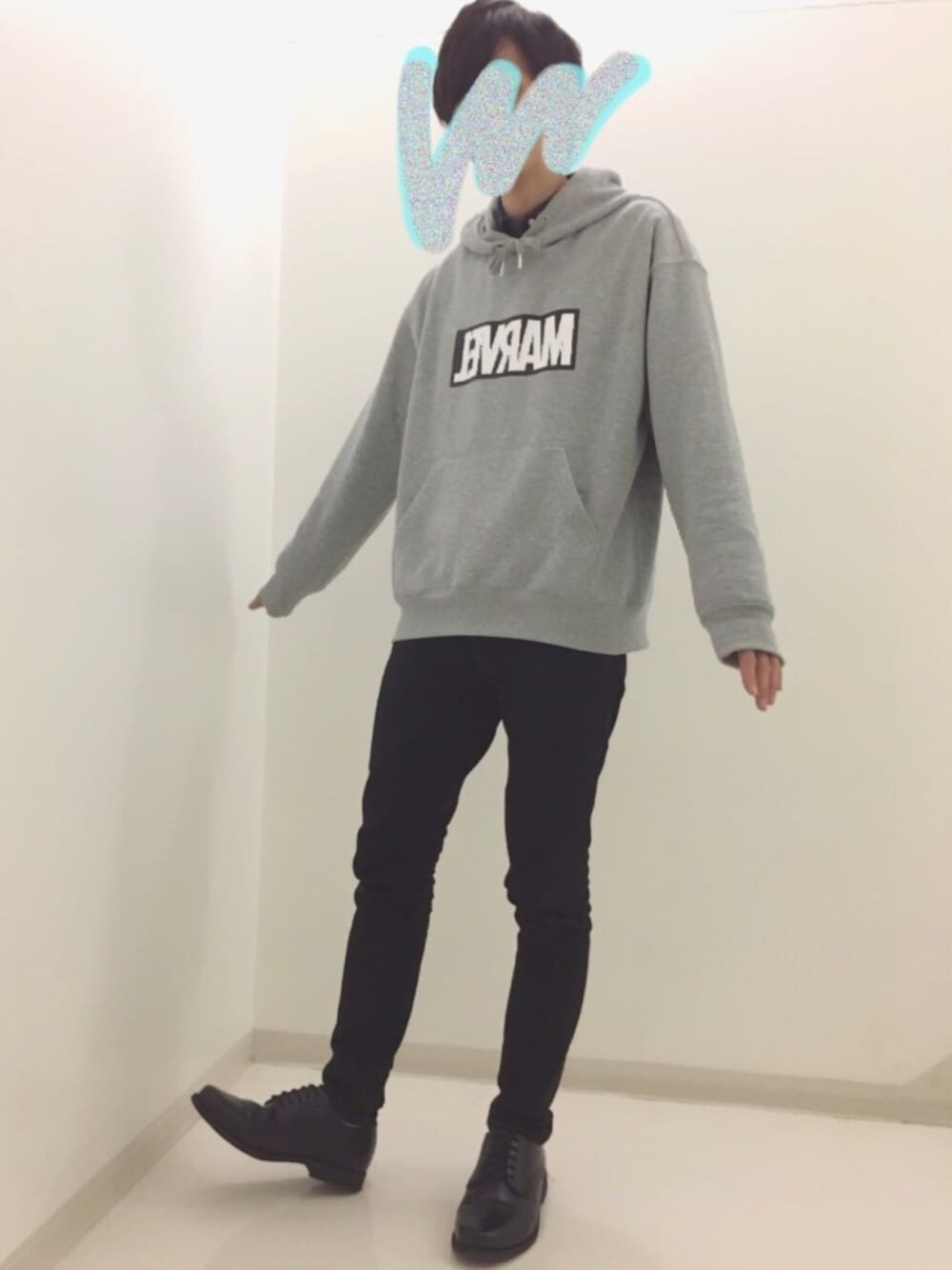 グレー系のパーカー、ブラック系のドレスシューズ、ブラック系のデニムパンツを着用したメンズの冬コーディネートの1枚目の写真