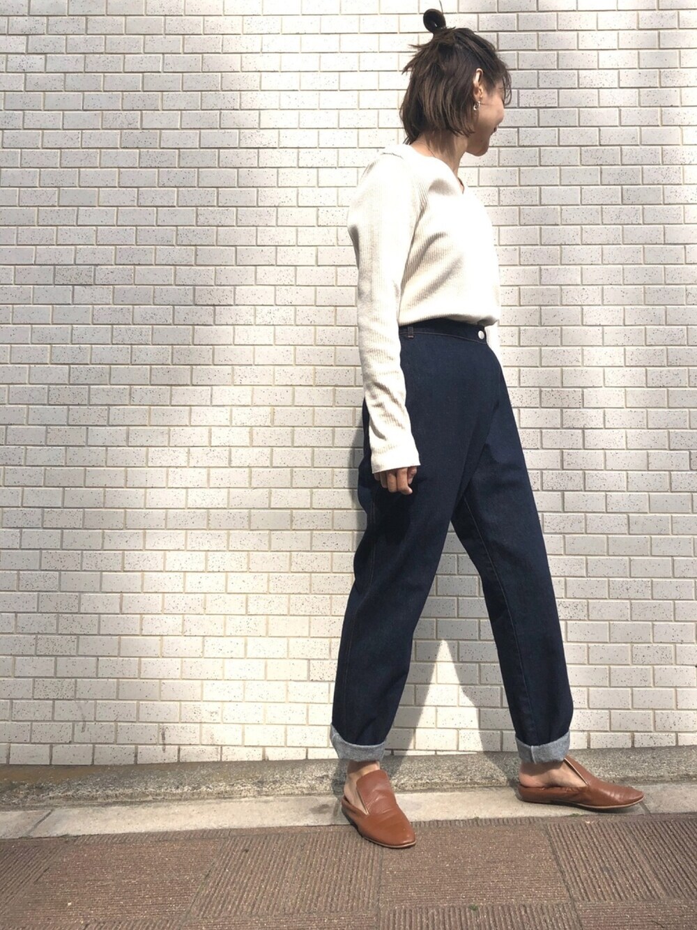 ベージュ系のTシャツ/カットソー、ブルー系のデニムパンツ、ブラウン系のバレエシューズを着用したレディースの冬コーディネートの1枚目の写真