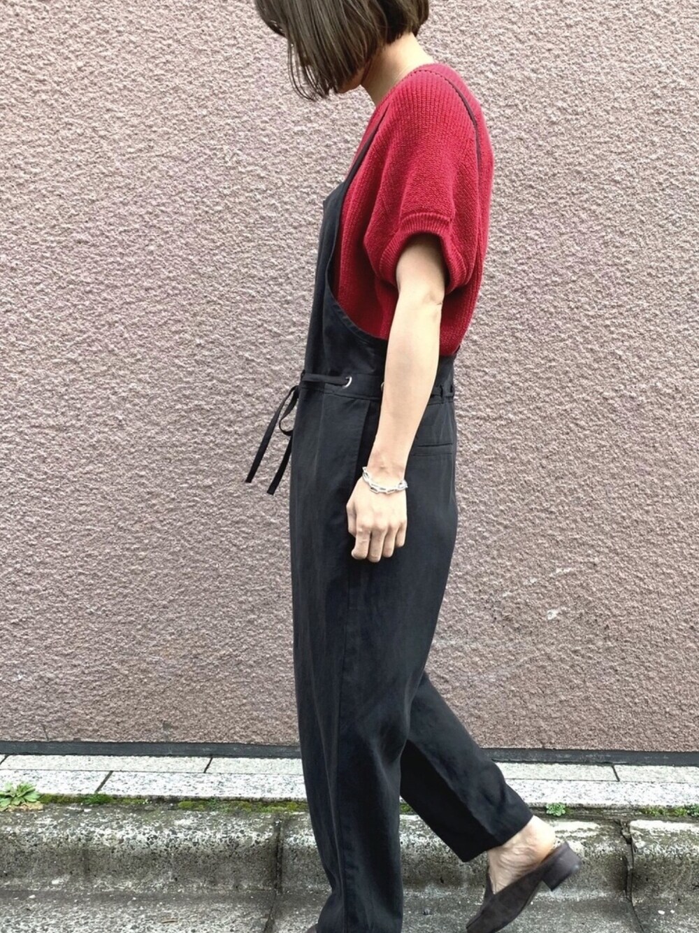 レッド系のニット/セーター、ブラック系のワンピースを着用したレディースの春コーディネートの1枚目の写真