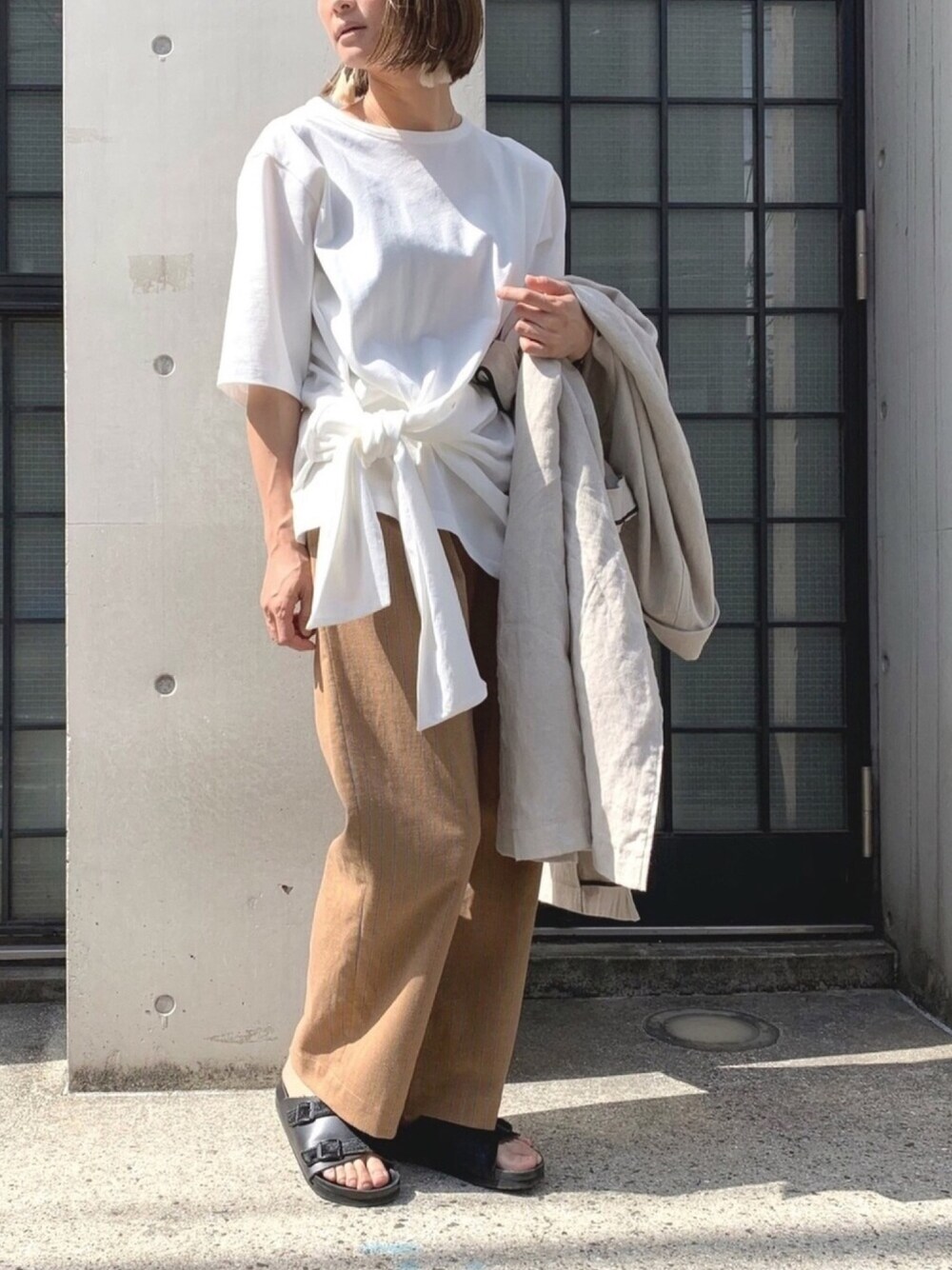 ホワイト系のTシャツ/カットソー、イエロー系のその他パンツ、ベージュ系のチェスターコートを着用したレディースの春コーディネートの1枚目の写真