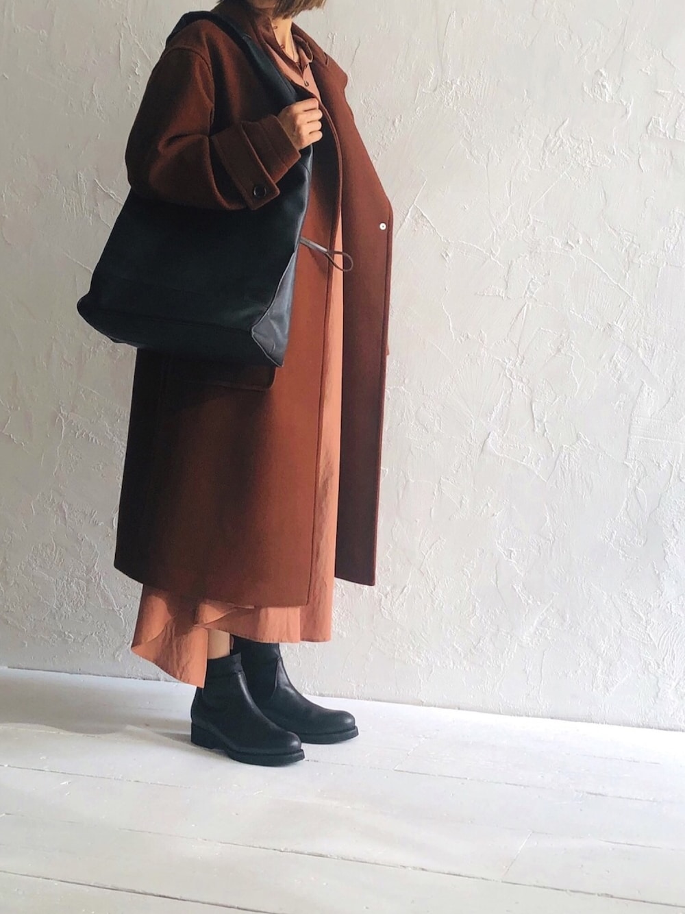 ブラウン系のダッフルコート、ブラウン系のワンピース、ブラック系のブーツを着用したレディースの秋コーディネートの1枚目の写真