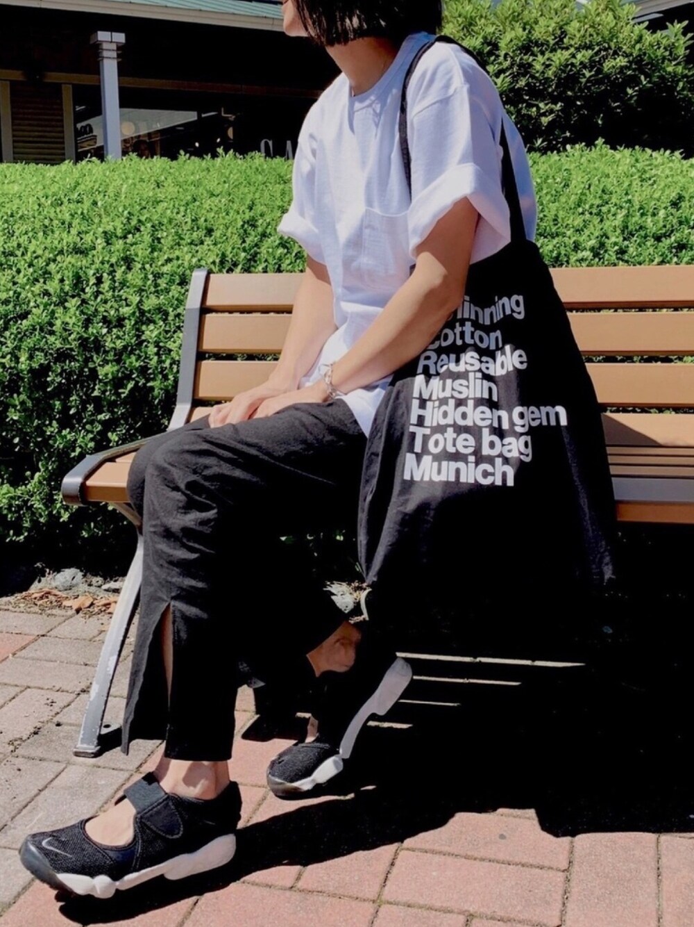 ホワイト系のTシャツ/カットソー、ブラック系のその他パンツ、ブラック系のトートバッグを着用したレディースの秋コーディネートの1枚目の写真
