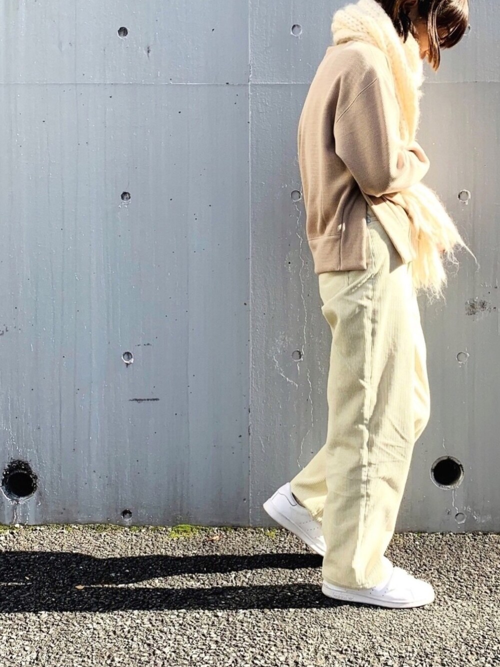 ベージュ系のスウェット、ホワイト系のデニムパンツ、ホワイト系のスニーカーを着用したレディースの秋コーディネートの1枚目の写真
