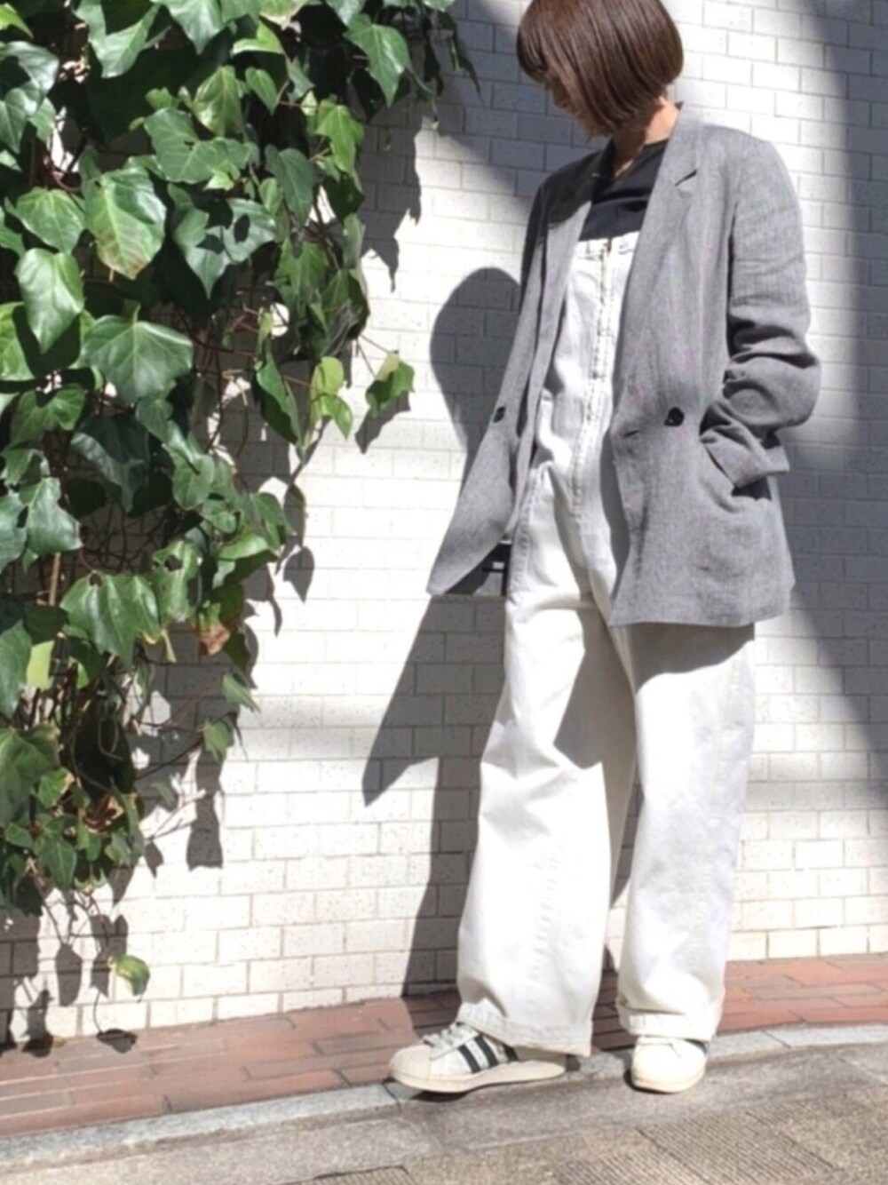 ブラック系のテーラードジャケット、ホワイト系のサロペット/オーバーオール、ブラック系のシャツ/ブラウスを着用したレディースの春コーディネートの1枚目の写真