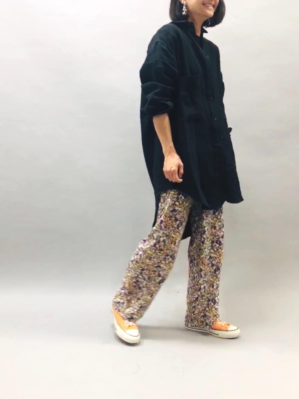 ホワイト系のその他パンツ、ブラック系のシャツ/ブラウス、オレンジ系のスニーカーを着用したレディースの春コーディネートの1枚目の写真