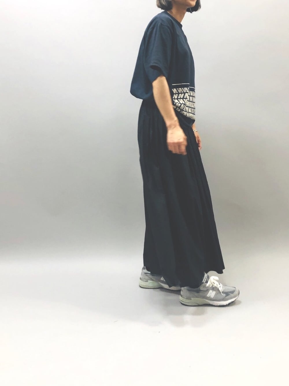 ブラック系のスカート、グレー系のスニーカーを着用したレディースの夏コーディネートの1枚目の写真