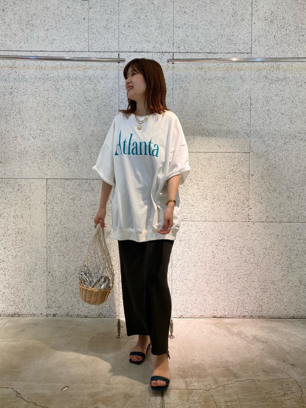 ホワイト系のTシャツ/カットソー、グレー系のスカート、ブルー系のサンダルを着用したレディースの春コーディネートの1枚目の写真