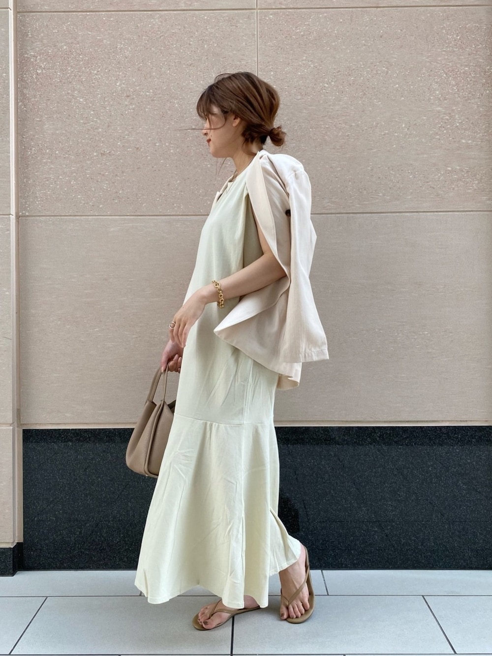 ベージュ系のテーラードジャケット、ホワイト系のワンピース、ベージュ系のハンドバッグを着用したレディースの春コーディネートの1枚目の写真