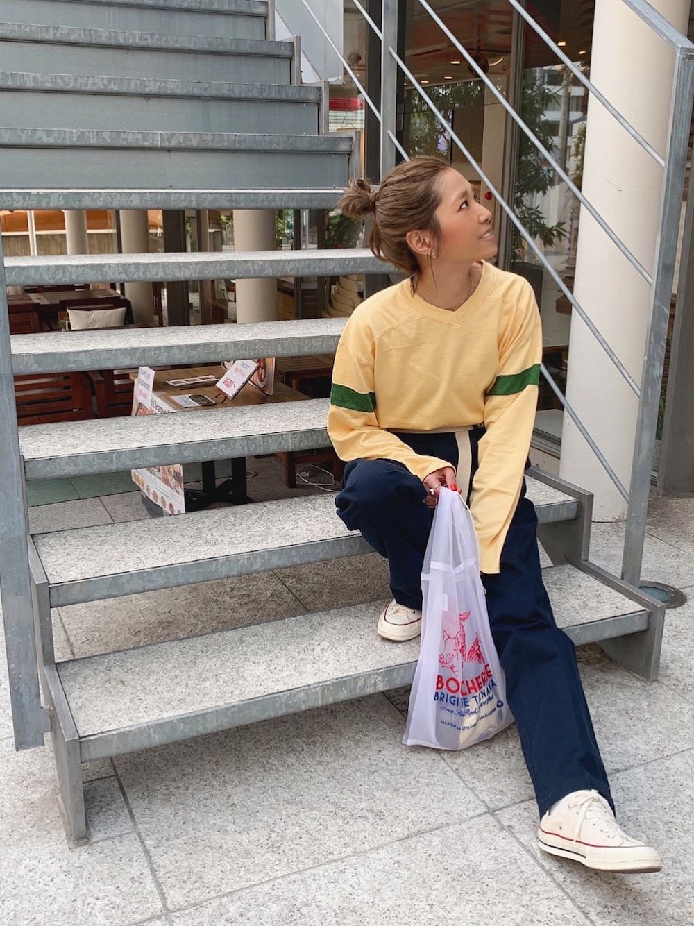 ベージュ系のTシャツ/カットソー、ブルー系のチノパンツ、シルバー系のアクセサリーを着用したレディースの春コーディネートの1枚目の写真