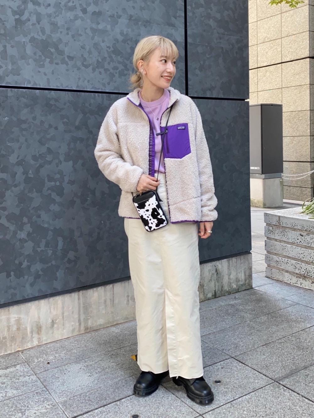 ブラック系のブーツ、パープル系のニット/セーター、ベージュ系のスカートを着用したレディースの秋コーディネートの1枚目の写真