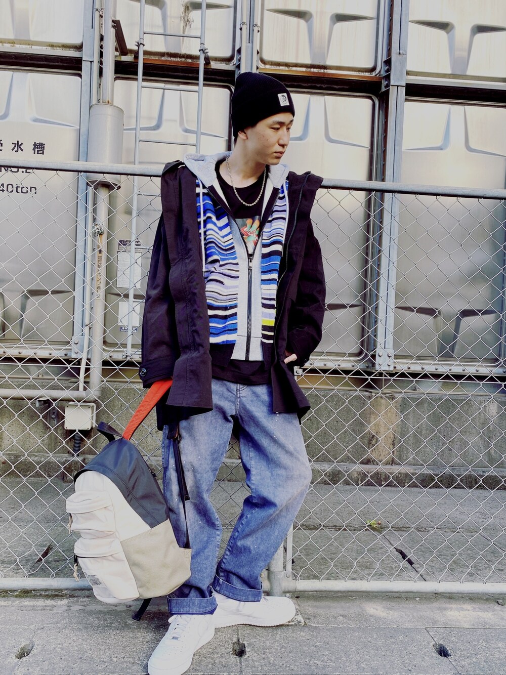 ブルー系のニット/セーター、ブラック系のTシャツ/カットソー、ブラック系のミリタリージャケットを着用したメンズの冬コーディネートの1枚目の写真