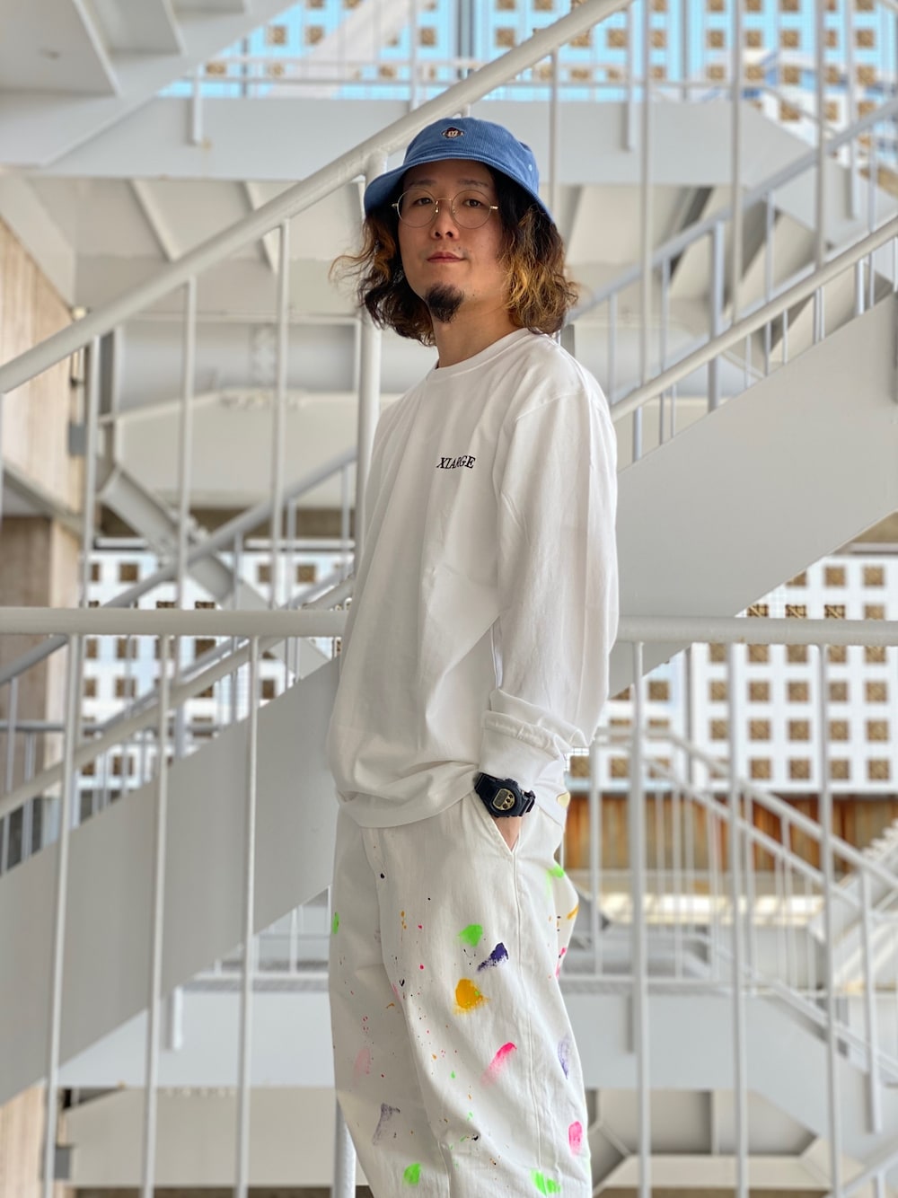「XLARGE、エクストララージ、ロンT、白Tシャツ、ペイント、ペイントパンツ、バケットハット、ホワイトコーデ、天使、ストリート」｜「XLARGEのL/S TEE NIGHT MANAGER（Tシャツ/カットソー、ホワイト系）」を使った、小川 礼偉さん（メンズ・169cm）の春コーディネートの1枚目の写真