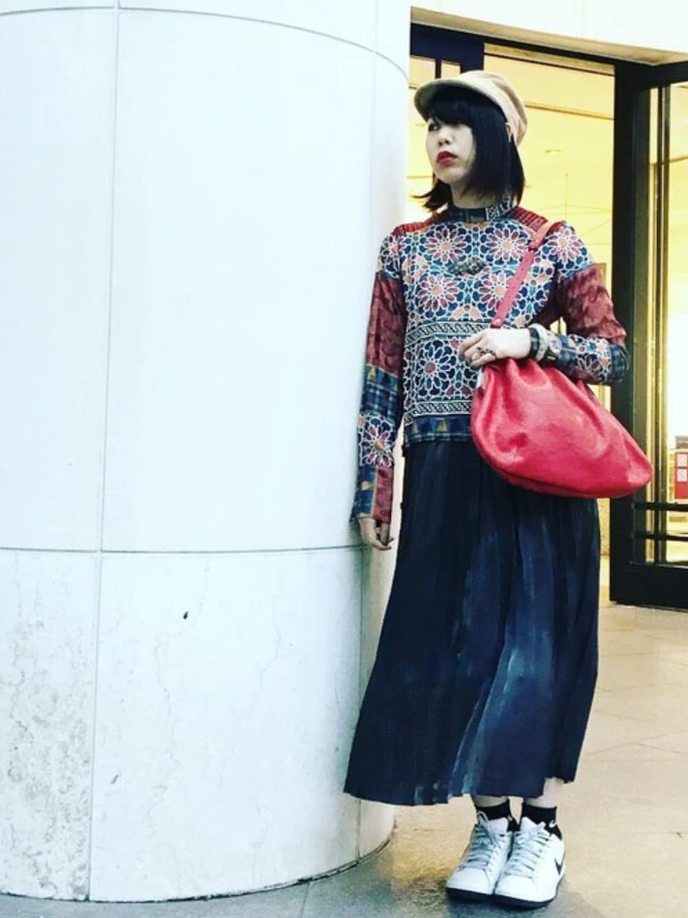 レッド系のショルダーバッグ、レッド系のシャツ/ブラウス、ブラック系のスカートを着用したレディースの冬コーディネートの1枚目の写真