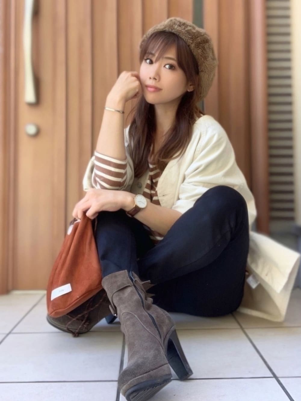 ブラウン系のTシャツ/カットソー、ホワイト系のブルゾン、ブラウン系のショルダーバッグを着用したレディースの秋コーディネートの1枚目の写真