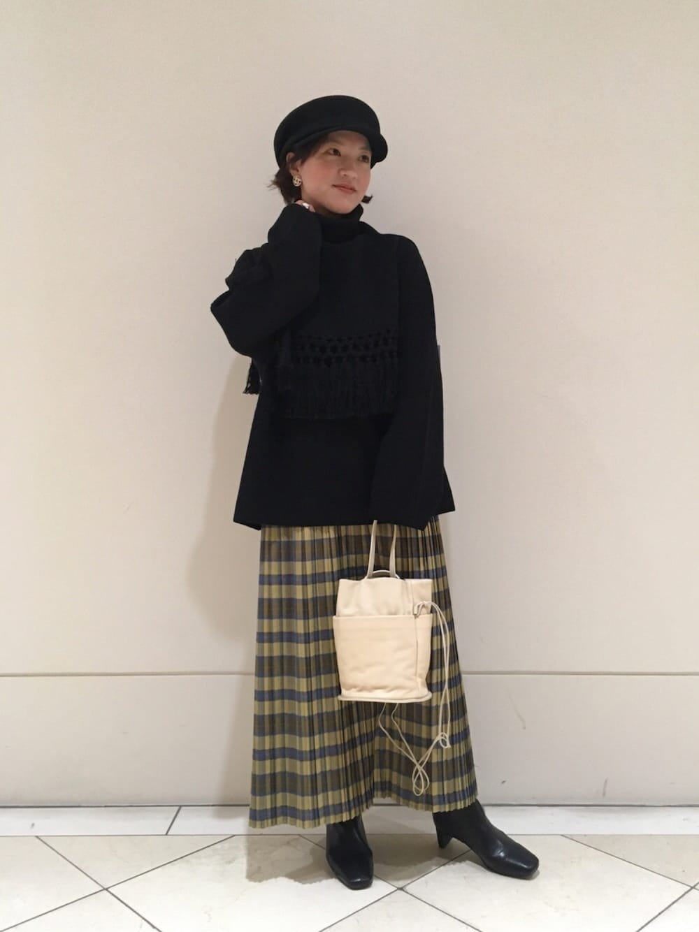 ブラック系のニット/セーター、ホワイト系のショルダーバッグ、イエロー系のスカートを着用したレディースの秋コーディネートの1枚目の写真