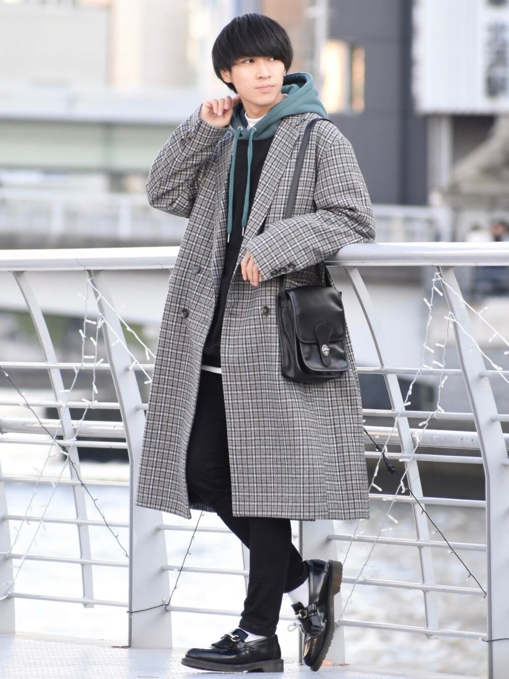 グレー系のチェスターコート、ブラック系のパーカー、ブラック系のスウェットを着用したメンズの冬コーディネートの1枚目の写真