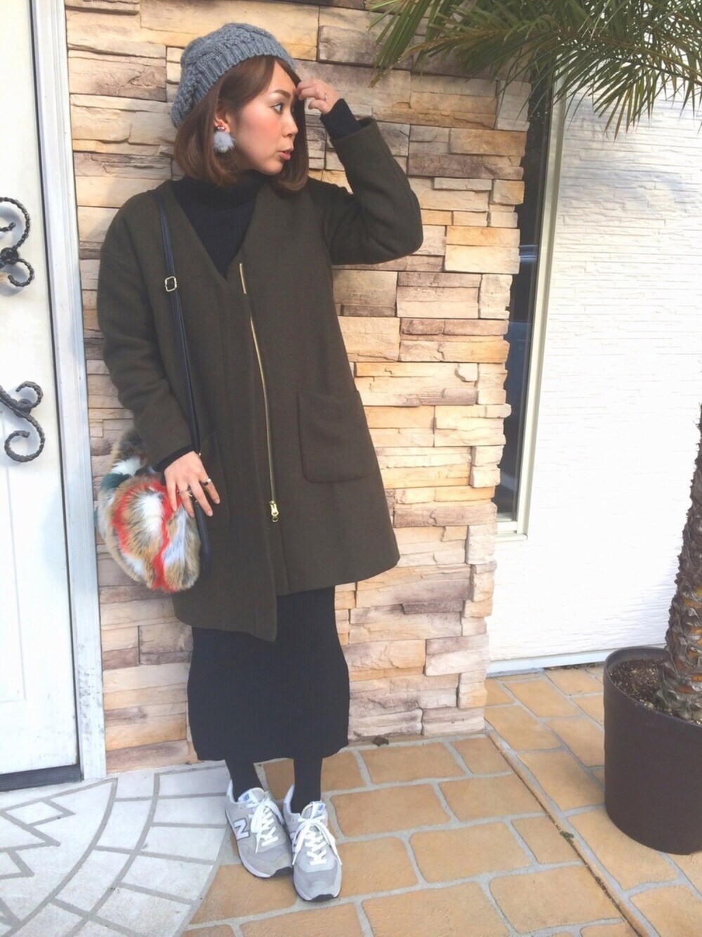 グリーン系のジャケット/アウター、ブラック系のニット/セーター、ブラック系のスカートを着用したレディースの冬コーディネートの1枚目の写真