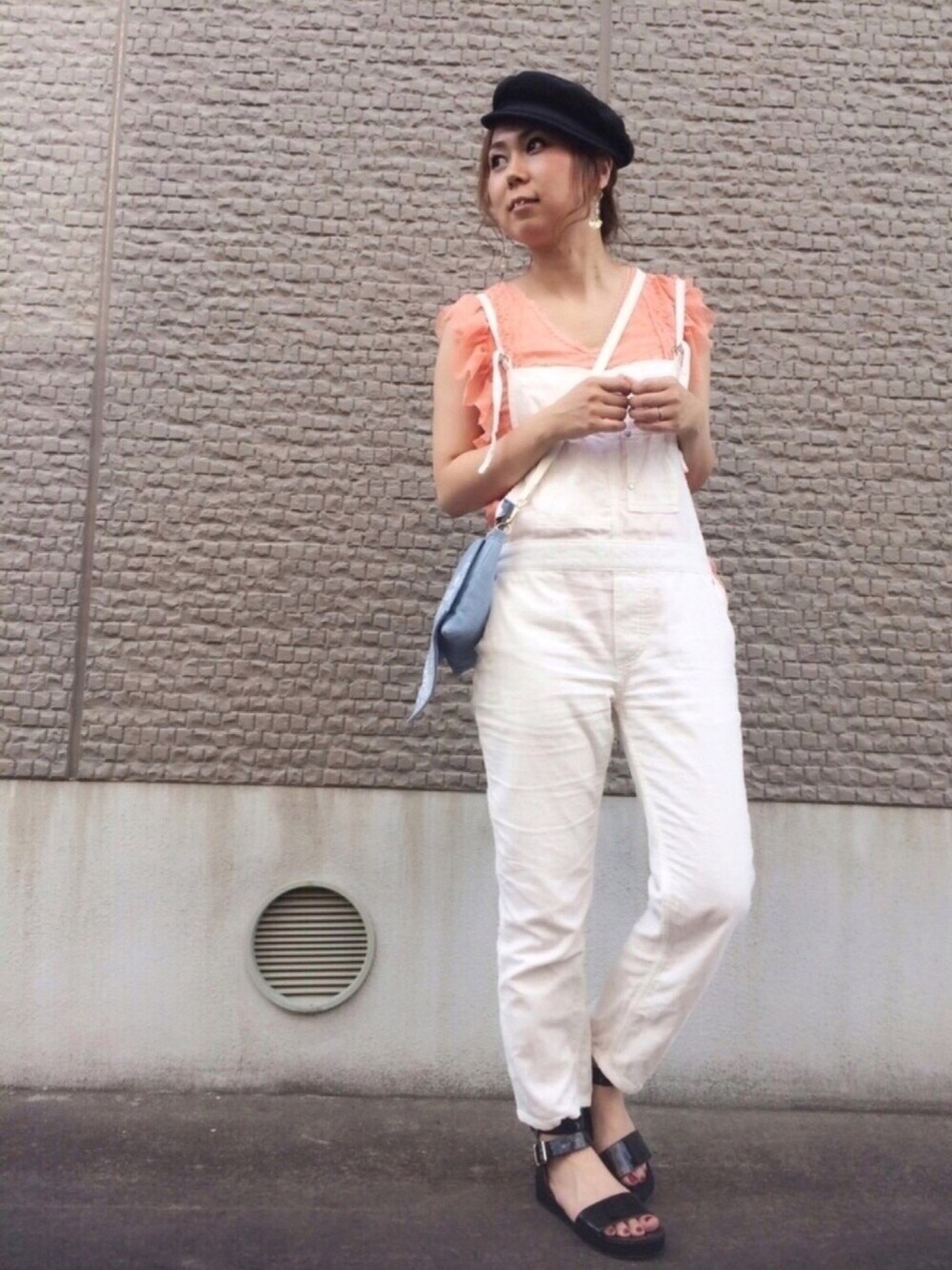 オレンジ系のシャツ/ブラウス、ホワイト系のサロペット/オーバーオール、ブルー系のショルダーバッグを着用したレディースの夏コーディネートの1枚目の写真