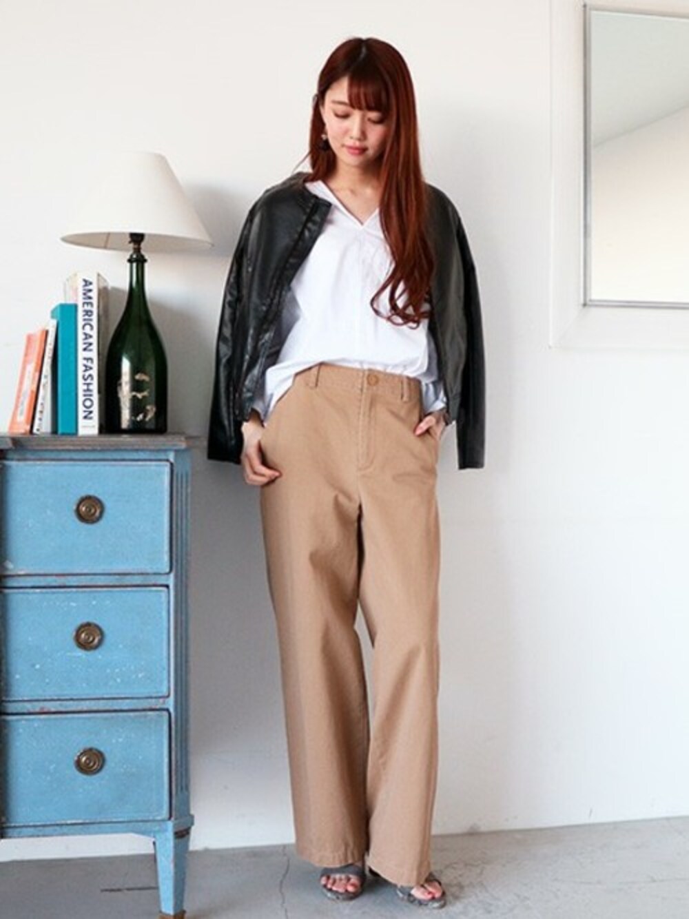 ブラック系のライダースジャケット、ホワイト系のシャツ/ブラウス、ベージュ系のチノパンツを着用したレディースの冬コーディネートの1枚目の写真