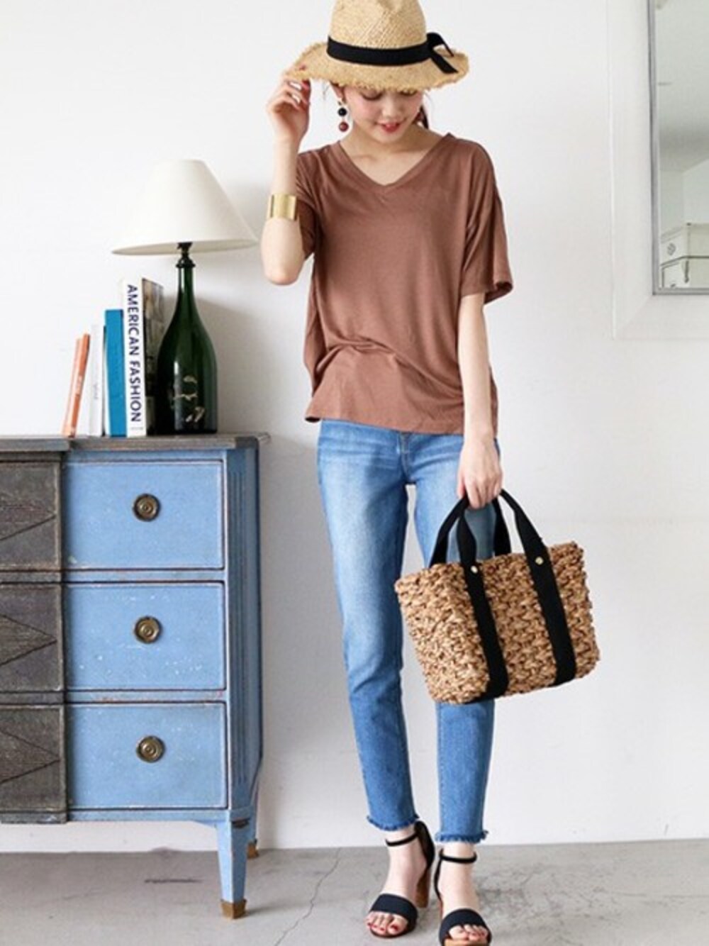 ベージュ系のTシャツ/カットソー、ブルー系のデニムパンツ、ブルー系のサンダルを着用したレディースの春コーディネートの1枚目の写真