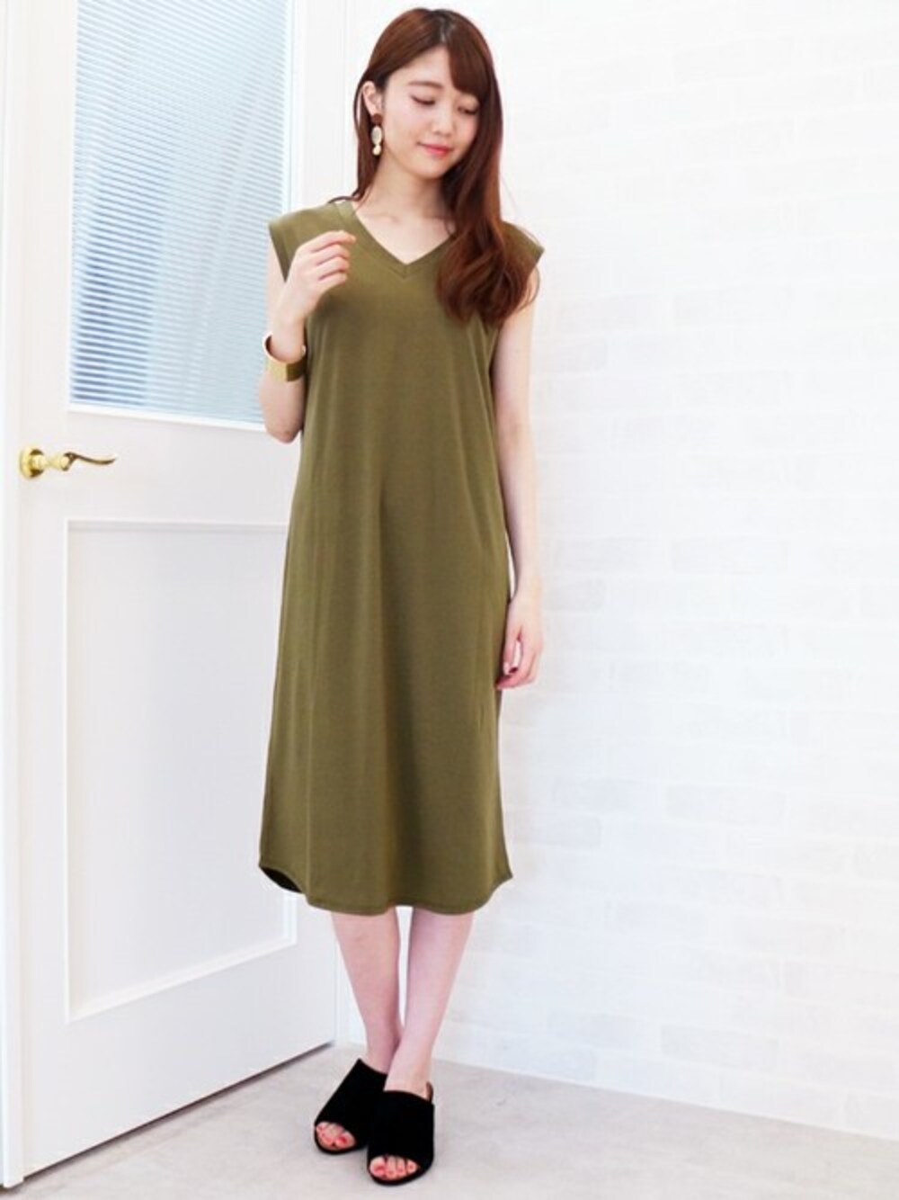 グリーン系のワンピース、ブラック系のサンダル、ホワイト系のピアス(両耳用)を着用したレディースの夏コーディネートの1枚目の写真