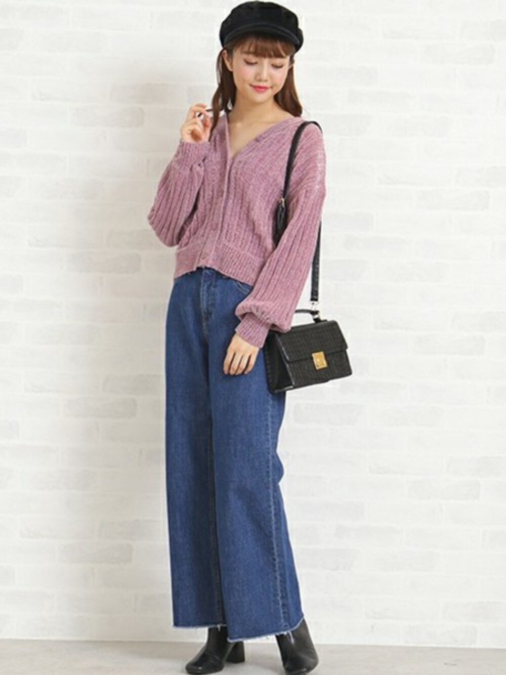 ピンク系のニット/セーター、ブルー系のデニムパンツ、ブラック系のショルダーバッグを着用したレディースの秋コーディネートの1枚目の写真