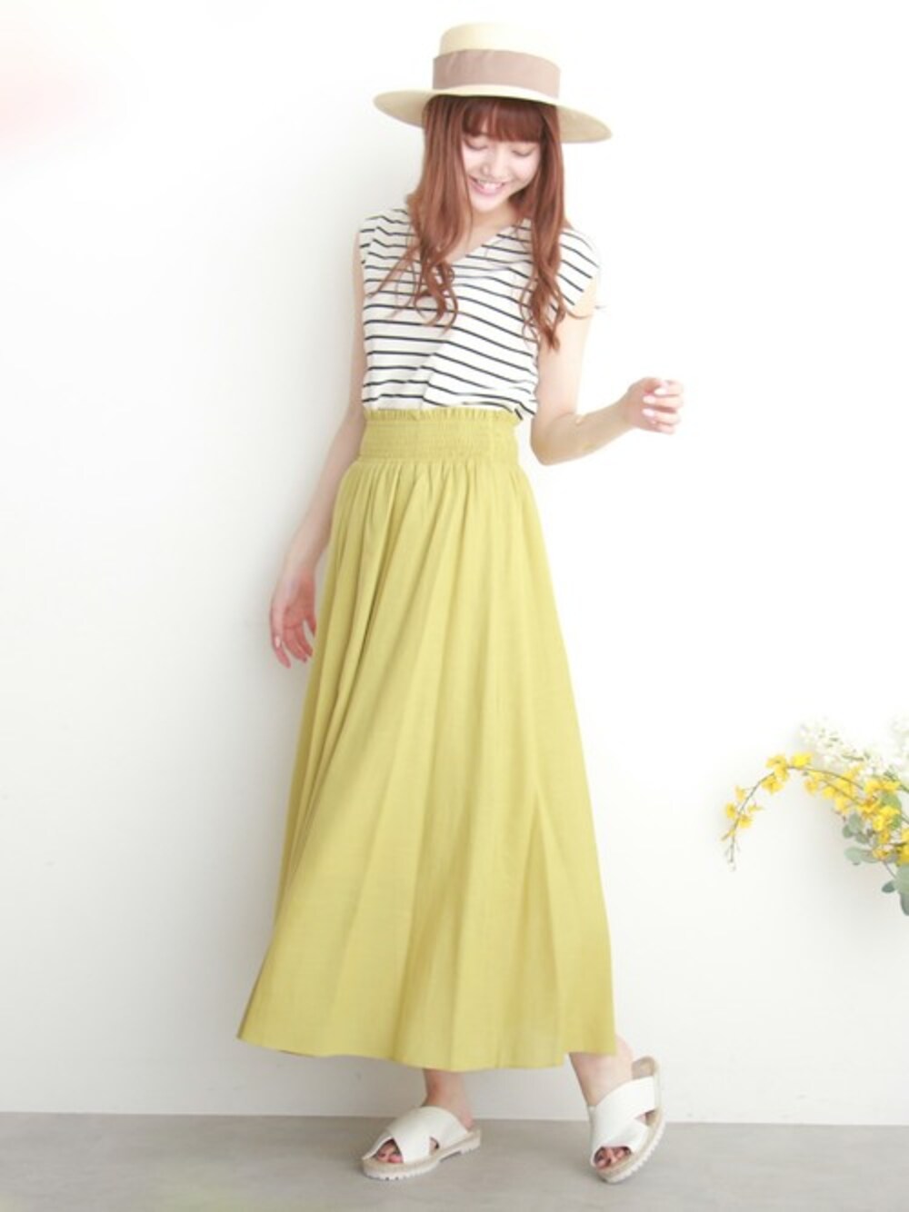 ホワイト系のニット/セーター、イエロー系のスカート、ホワイト系のサンダルを着用したレディースの夏コーディネートの1枚目の写真