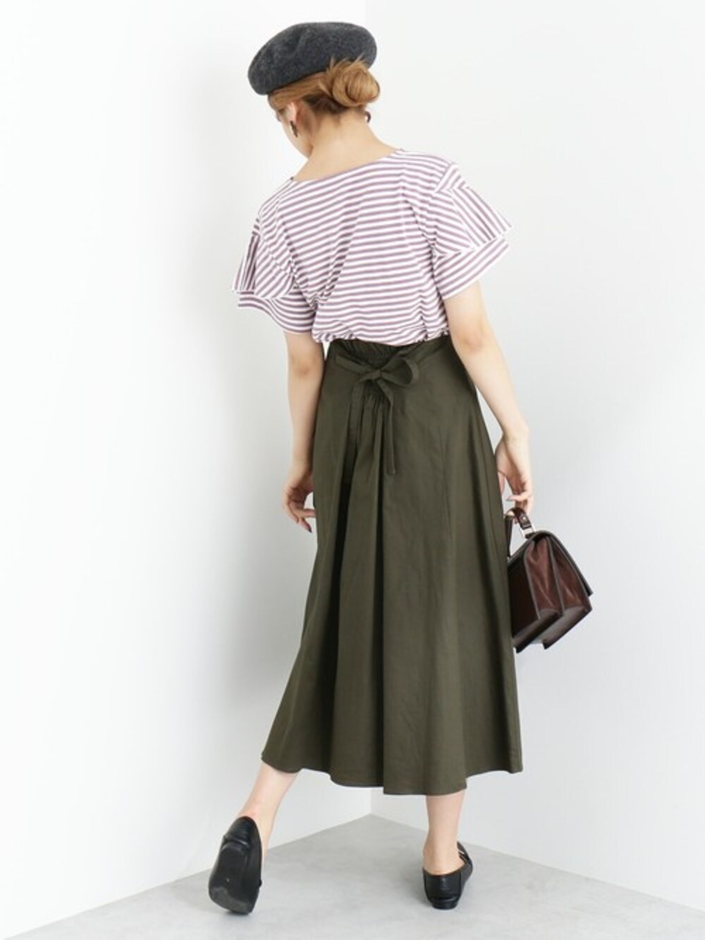 パープル系のTシャツ/カットソー、グリーン系のスカート、グレー系のハンチング/ベレー帽を着用したレディースの夏コーディネートの1枚目の写真