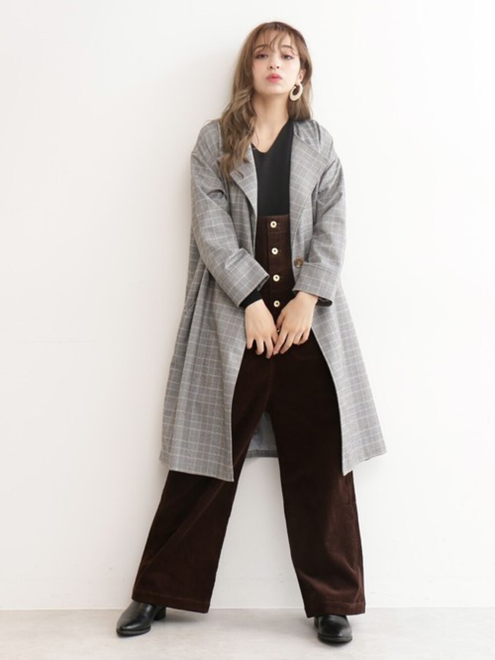 グレー系のブルゾン、ブラック系のニット/セーター、ブラウン系のサロペット/オーバーオールを着用したレディースの秋コーディネートの1枚目の写真