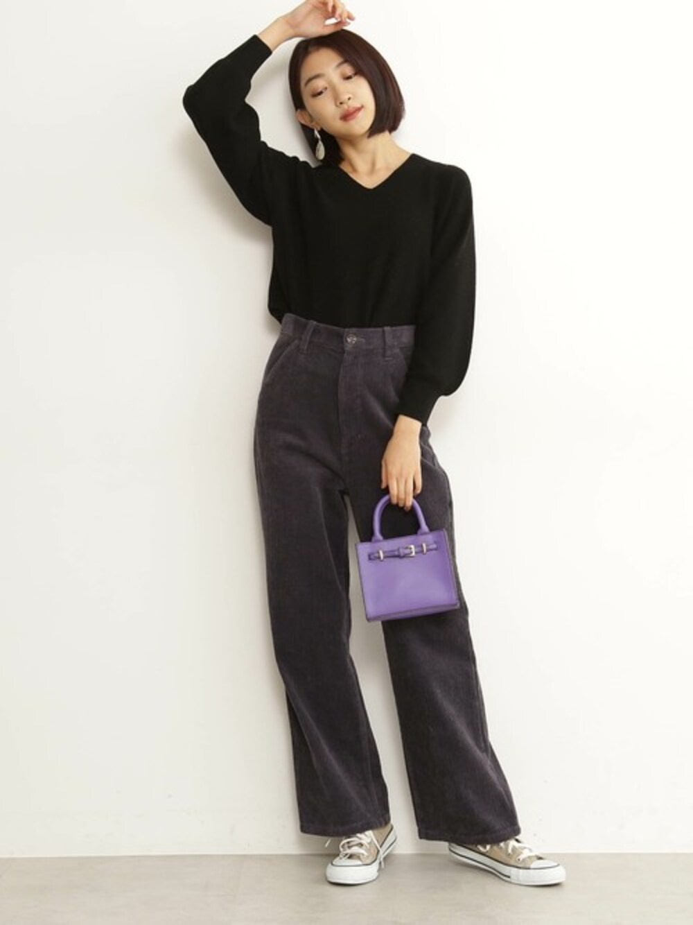 ブラック系のニット/セーター、グレー系のその他パンツ、パープル系のショルダーバッグを着用したレディースの冬コーディネートの1枚目の写真